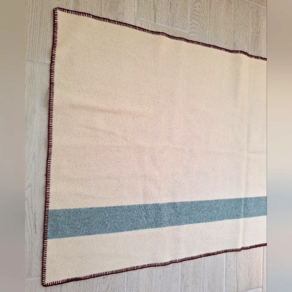 The Woolrich Woman cream, brown and blue Woolrich sheep logo heavy wool blanket